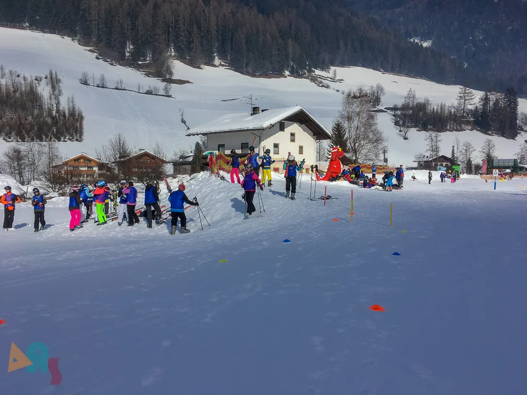 Übungswiese mit mehreren Gruppen vor den Häusern.